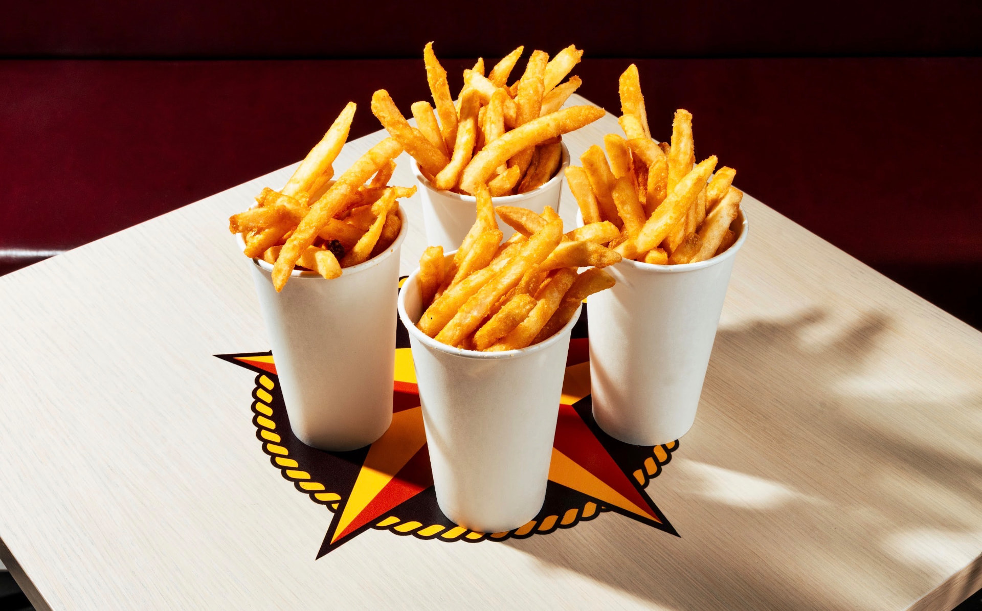 Four cups of golden crinkle-cut fries on a Hotbirds star